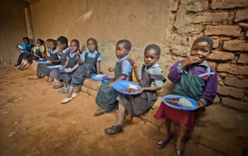 I bambini si siedono insieme per mangiare a scuola.