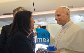 Papa Leone XIV ha tra le mani maglietta e tazza Mary's Meals