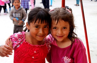 Due amici posano insieme in un parco giochi in Ecuador.