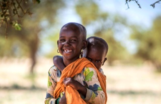 Un giovane ragazzo porta suo fratellino sulla schiena a Turkana, in Kenya.