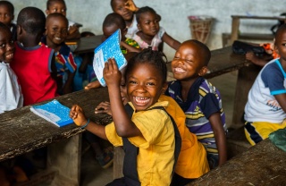 Una giovane ragazza esulta in una classe in Liberia.