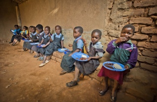 I bambini si siedono insieme per mangiare a scuola.