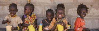 A group of children sit together to eat at school.