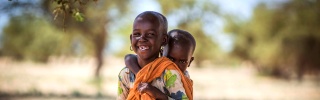 Un giovane ragazzo porta suo fratellino sulla schiena a Turkana, in Kenya.
