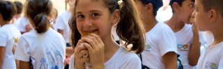 Una giovane ragazza gusta il cibo a scuola in Siria.
