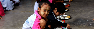 I bambini si siedono insieme per mangiare a scuola in Thailandia.