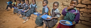 I bambini si siedono insieme per mangiare a scuola.