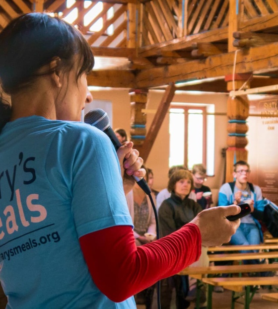 Un sostenitore di Mary's Meals parla a una folla durante un evento di raccolta fondi.