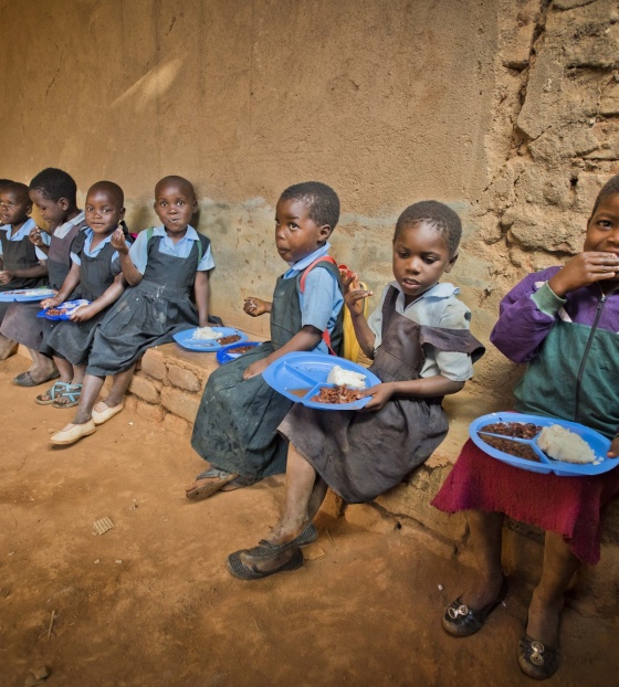 I bambini si siedono insieme per mangiare a scuola.