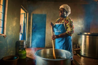 Un cuoco volontario mescola un pentolone di cibo in Malawi.