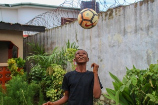 Un giovane ragazzo gioca con un pallone da calcio.